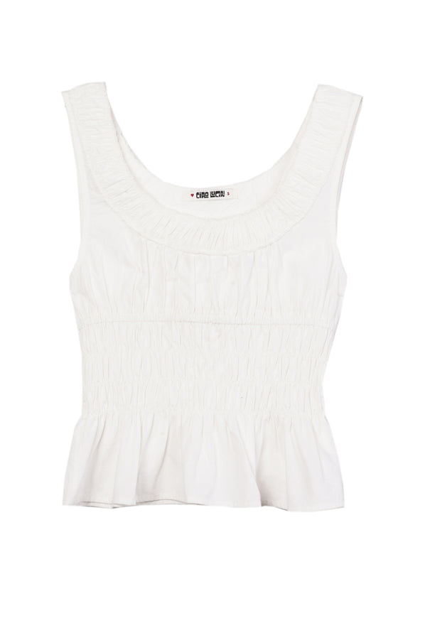 A white thick strapped tank top with a shirred scoop neckline and tiered rows of smocking around the waist against a white background. 
