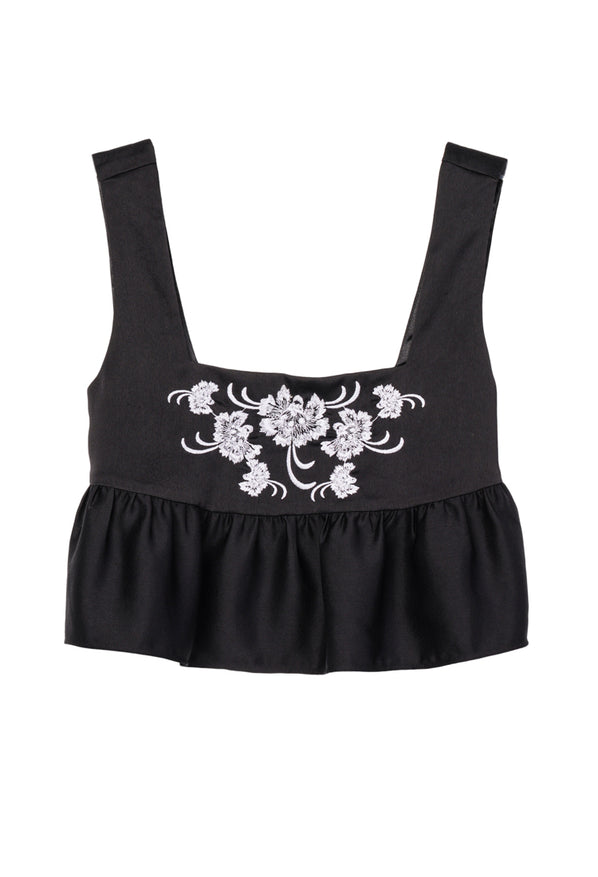 Cropped sleeveless black satin peplum top with floral embroidery on a white background