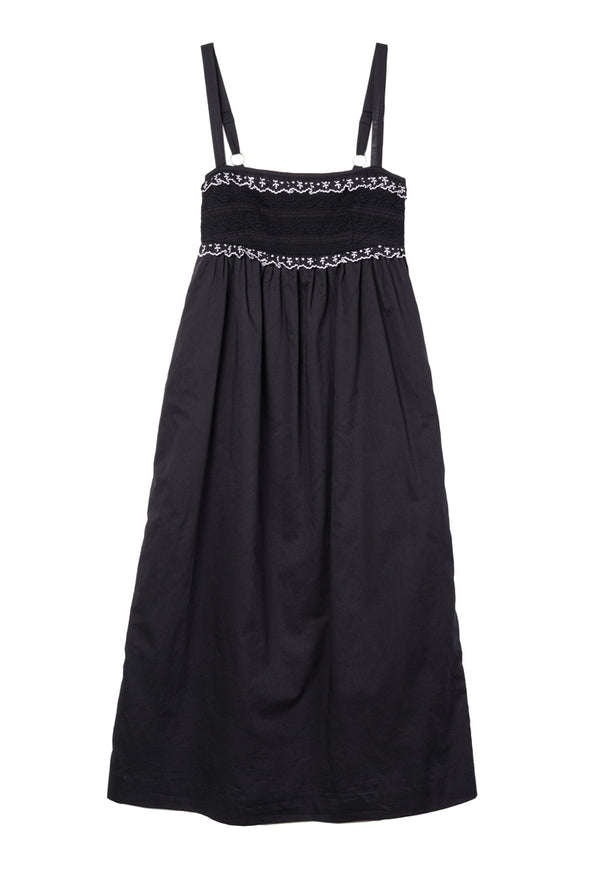 Black midi length tank dress with lace bodice and white embroidered ruffle trim details against a white background